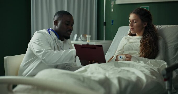 Empathetic doctor sits with a young patient, ensuring she understands her treatment.