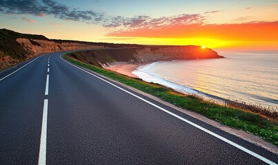 Coastal highway curves towards ocean sunset, offering scenic drive