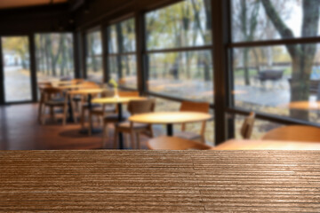 Empty wooden table in stylish cafe. Space for design