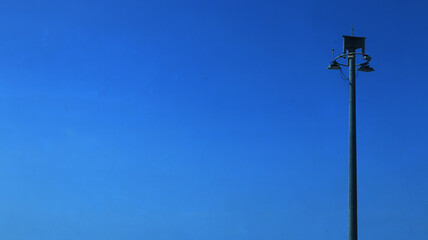 Electric light on blue sky in sunny weather. Lamp for home garden lighting.