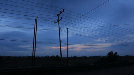 Network of electric cables on electric poles with a clear blue sky in the afternoon