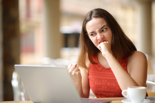 Angry woman checking laptop in a restaurant