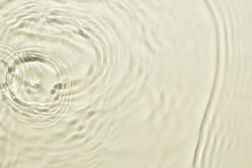Natural background of water in summer. Beige surface. Clear water with ripples and splashes. water waves in sunlight The water surface has waves.