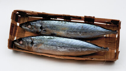 Pindang basket fish, Indonesian fish called ikan pindang or ikan keranjang in a bamboo basket isolated on white with copy space. Clipping path. Cooking content