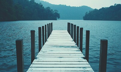 Fototapeta premium Wooden pier on calm lake with forest background, ideal for travel or relaxation themes