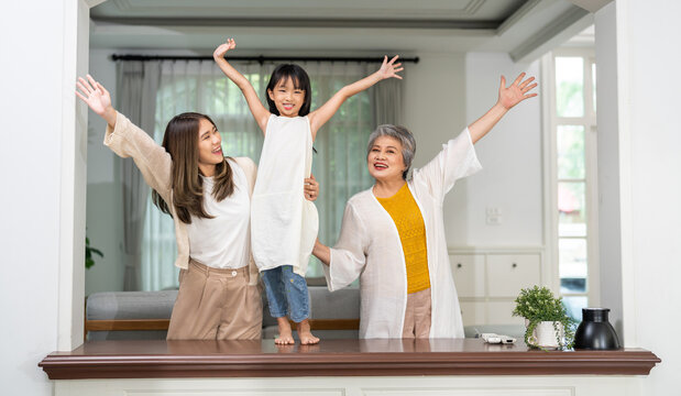 Three generation asian family together at home, happy grandmother, mother and daughter bonding, standing by window arch, family love and connection, lifestyle of asian family with different ages