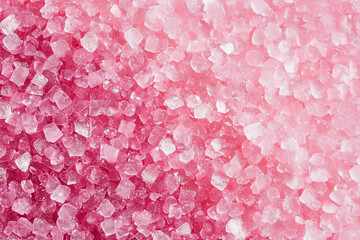 close up of pink salt crystals on a pink background. The salt crystals are small and pink, and they are scattered throughout the image. The pink background creates a soft and soothing atmosphere