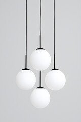 Modern chandelier with a cluster of hanging white glass orbs isolated on white background