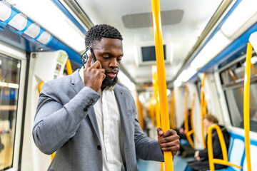 Businessman talking on smartphone while riding subway train