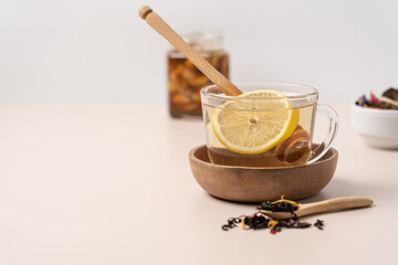 Tea, lemon, honey in glass mug on light background with copy space. Health drink close-up view