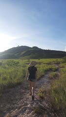 mulher caminhando em area de lavrado e montanhas em roraima