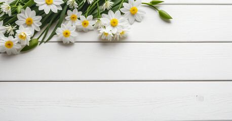 Obraz premium Bouquet of white flowers arranged across the top left corner of a white wooden table. Concepts of purity, freshness and simplicity.