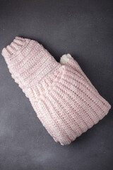 Knitted woolen light pink sweater, folded knit pullover on grey background, top view. Copy space