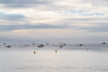Bucolic view of Mediterranean sea with some nautical vessels at sunrise.