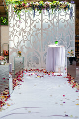 Elegant wedding setup with floral decor. A beautiful wedding altar adorned with flowers and petals, set up for a romantic ceremony in a charming venue.