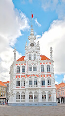 Obraz premium Majestic Ornate White and Salmon Building Stands Tall Under a Cloudy Blue Sky
