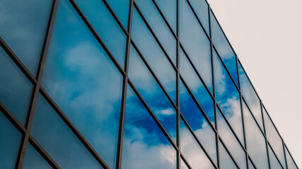 reflection of blue sky with clouds in an office building window