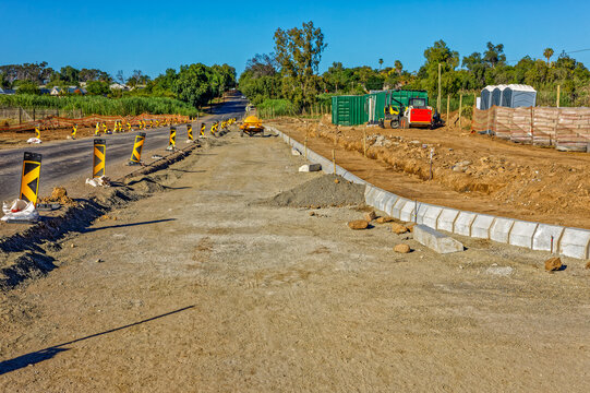 Road widening activities in a small town in the Little Karoo, Western Cape, South Africa with construction equipment in the background