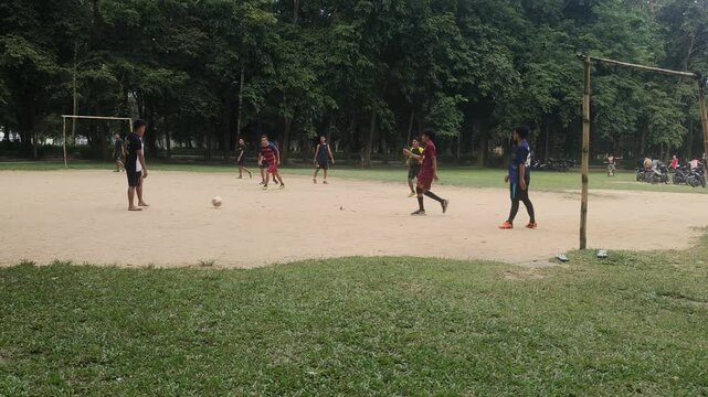 Kendari, Indonesia- January 12, 2025: Students play mini football on the dirt field as a routine every afternoon with five players per team.