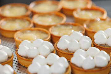 Delicious pastries with meringue and custard in bakery factory