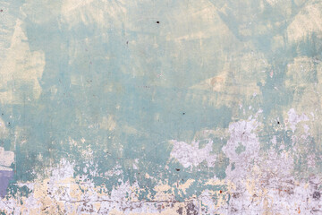 Weathered peeling paint on old concrete wall in subtle pastel hues