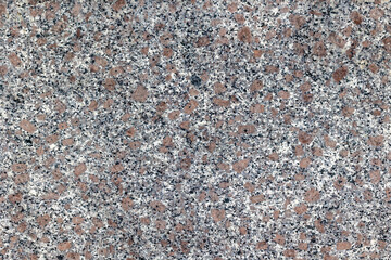 Granite surface texture with brown and gray flecks