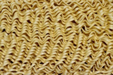 a close up view of uncooked, wavy instant ramen noodles