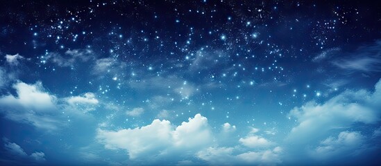 Starry night sky with the Milky Way in shades of deep blue and light gray clouds, vibrant stars scattered across the top half of the image.