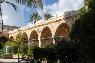 Obraz premium Akko, Israel - January 23, 2025, Courtyard of Al-Jazeera Mosque with orange and lemon trees. Cloudy