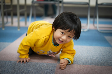 机の下に潜って遊ぶ男の子 / Boy playing under the desk