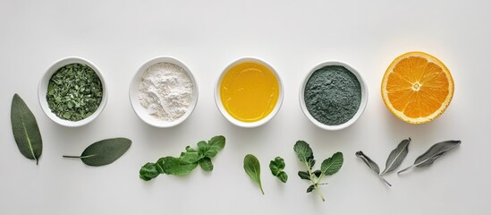 Vibrant vegan clean ingredients in white bowls arranged in a line on a light background including green herbs, orange slice, and powders