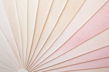 A close-up view of a fan-shaped arrangement of textured paper in soft pastel colors, ideal for design