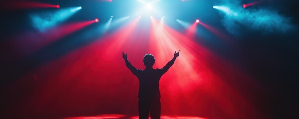 Male performer in spotlight on stage with vibrant red and blue lights