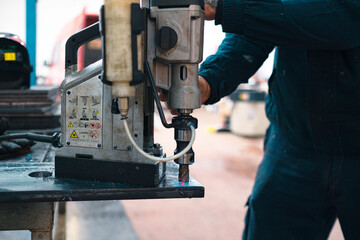 Skilled locksmith operating heavy-duty drill machine