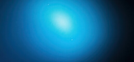Obraz premium Deep Blue Abstract: A serene abstract image of a deep blue background with subtle light emanating from the center, creating a sense of depth and mystery. 