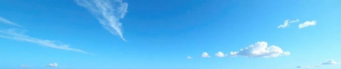 Blue sky with wispy cirrus clouds and a few scattered puffy clouds, wispy, airy