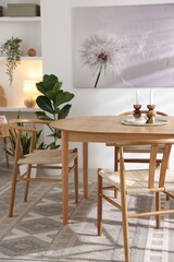 Stylish room with wooden table, chairs and houseplants. Interior design