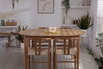 Stylish wooden table with chairs and decor indoors. Interior design