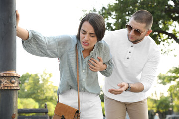 Man trying to help woman with heart attack in park