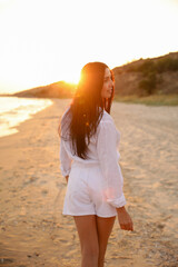 Young beautiful woman on beach at sunset