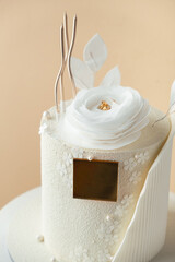 Luxury birthday cake with white chocolate and fondant icing decorated with edible flower and golden...