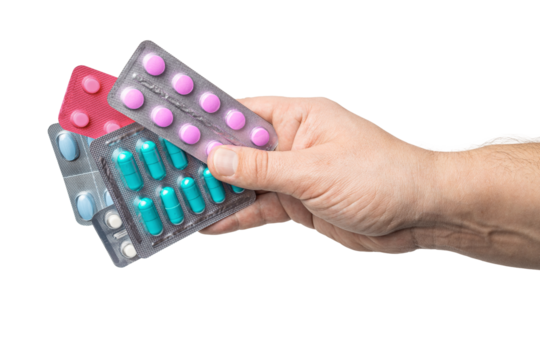 Male hand holding various blister packs with medicine capsules, antibiotic pills, or painkillers, isolated on transparent background. healthcare and treatment concept