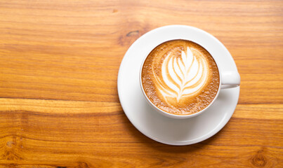 Hot Latte Coffee in a white cup on wooden table background