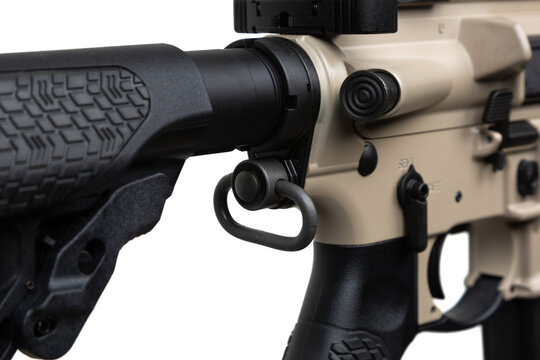 Close-up of a tactical rifle's stock and receiver, showcasing the detailed texture and components, including the buffer tube, sling attachment point, and safety selector switch