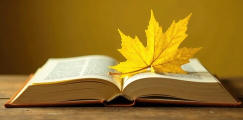 A delicate yellow leaf curled around a book spine, book art, yellow
