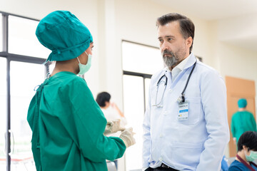 Professional medical senior doctors wearing stethoscopes and nurse in scrubs engage in discussion within hospital setting, physician specialties and white coat to diagnose heart attack symptom.