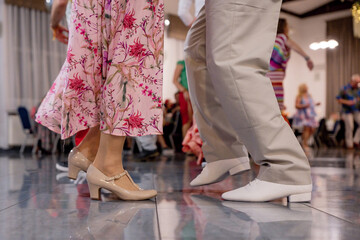 Details of the legs and shoes of a young caucasian couple dancing, Legs of ballerinas dancing at the wedding party, close-up, Legs of a young couple dancing in the dance hall during a wedding