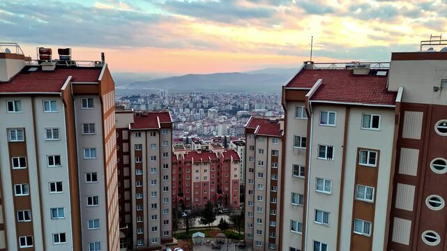 The video shows completed multi-story residential buildings. The structures feature a uniform architectural design, with parking areas and landscaping visible within the residential complex.