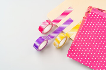 Colorful decorative tape and patterned paper arranged on a table for creative projects