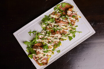 Roast beef di carne con rucola e formaggio fuso servito in una braceria 